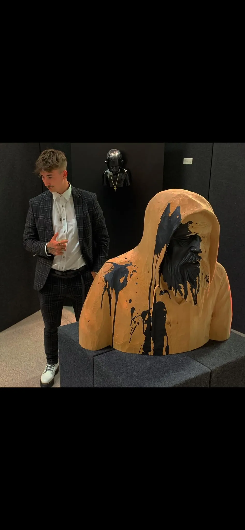 Rupert Elias Kreuzer mit einer Holzskulptur auf der Unika 2021